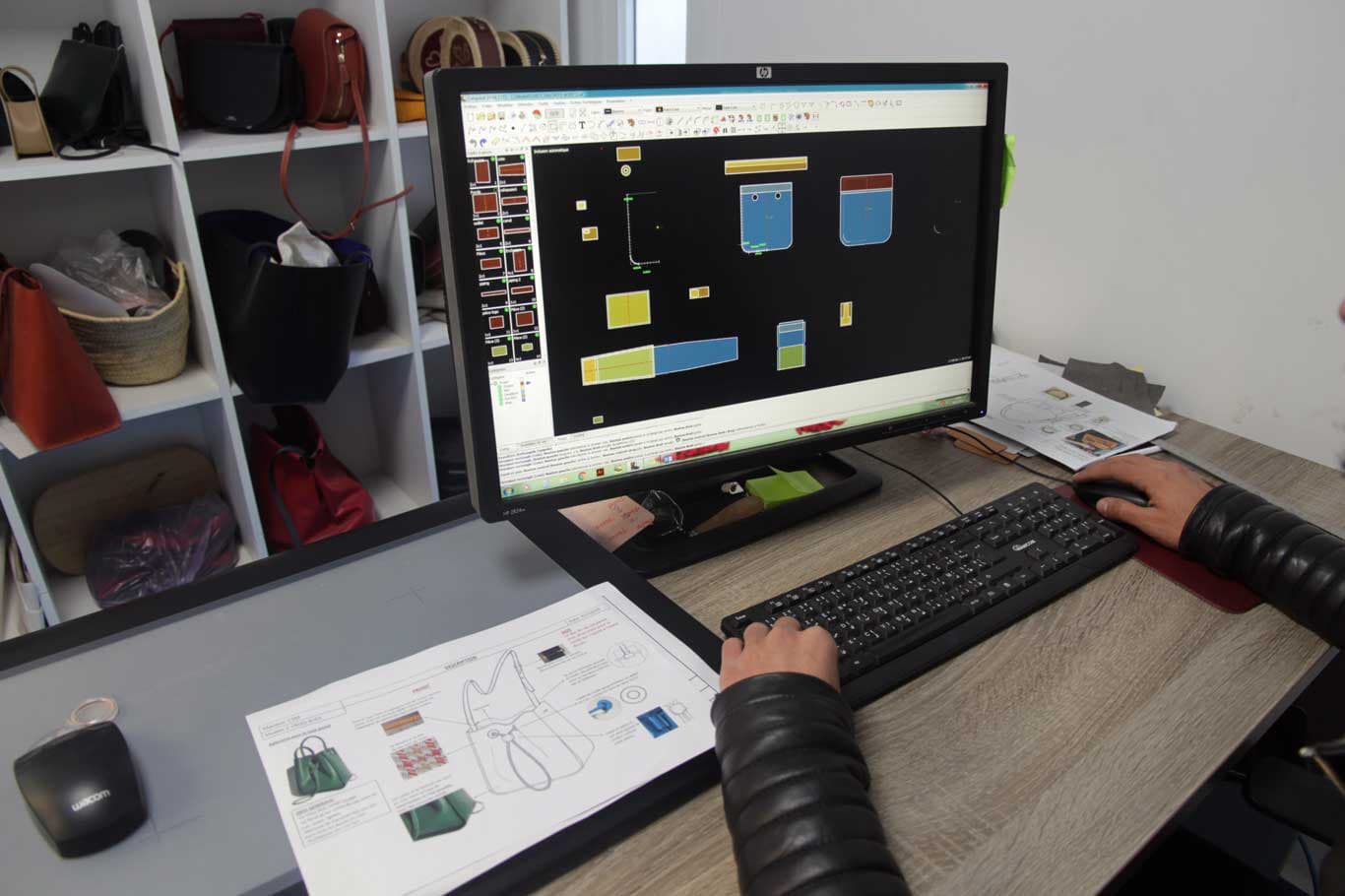 Leather pattern nested in CAD beside a printed tech pack at Saccent in Fes, Morocco