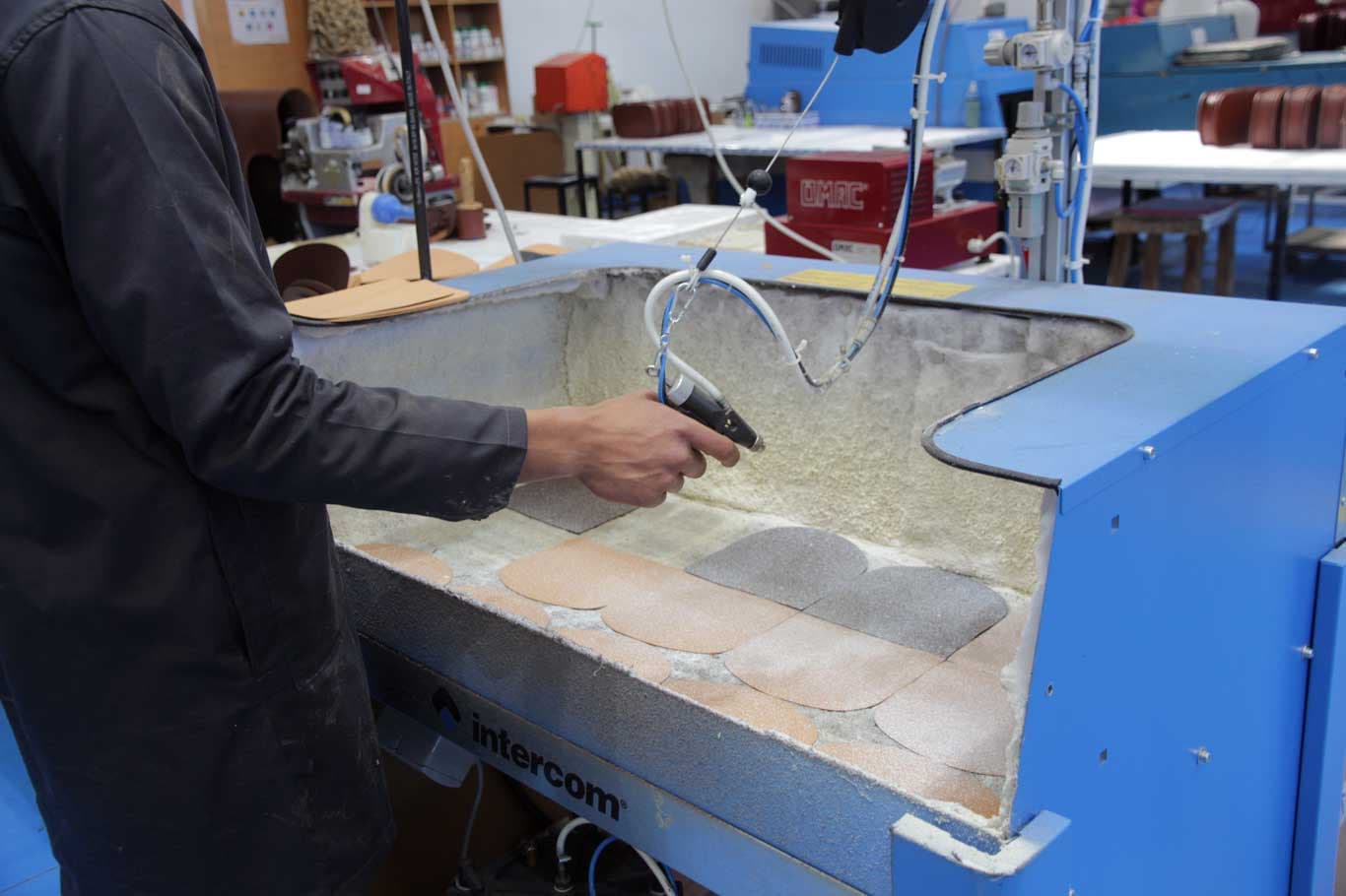 Adhesive applied to cut leather parts in a spray booth at Saccent in Fes, Morocco
