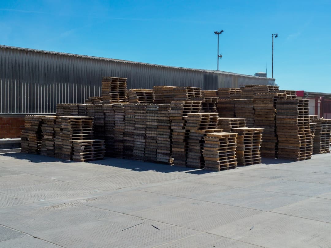 Stacks of wooden pallets outside a warehouse